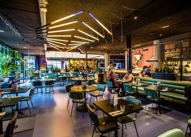 the_student_hotel_amsterdam_city_the_commons_dining_area_with_blue_seats.jpg
